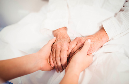 manos de cuidadora y paciente