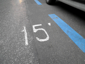Foto de un aparcamiento con marcas azules y el texto 15' 